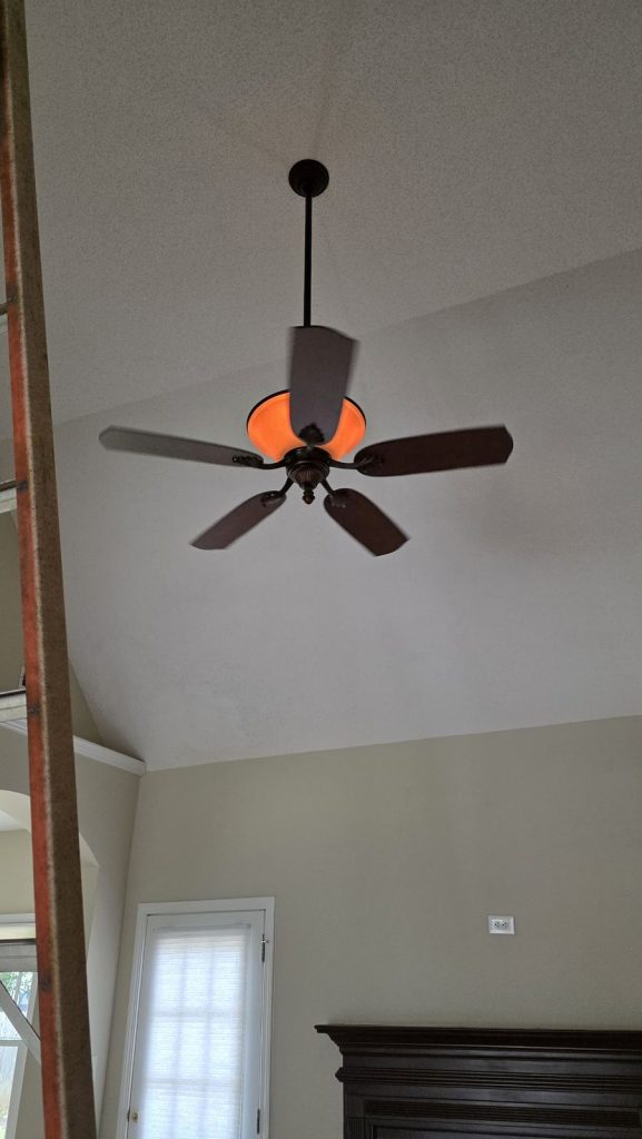 Ceiling fan with light installed on a downrod on a vaulted ceiling in a Newnan, GA home by Shocking Electric Solutions