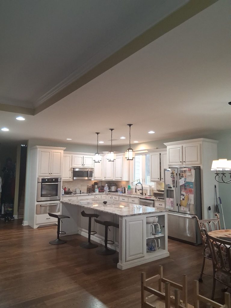 Recessed ceiling lights and pendant lights over a kitchen island in a Newnan, GA home, installed by Shocking Electric Solutions