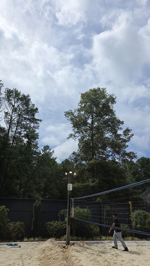Wood light pole with LED flood lights at a backyard sand volleyball court in Fayetteville, GA, installed by Shocking Electric Solutions