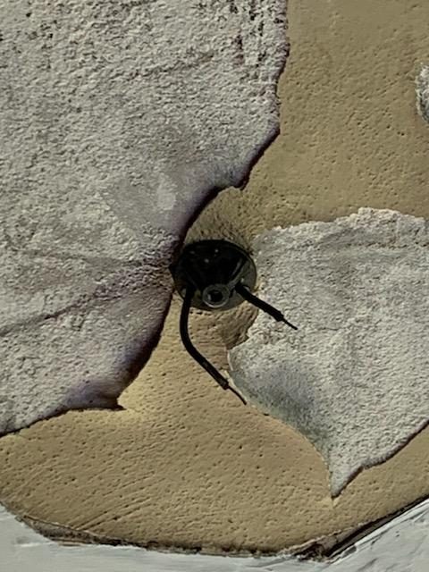 Old ceiling electrical box surrounded by cracked and crumbling plaster in a 1930s-era Newnan home