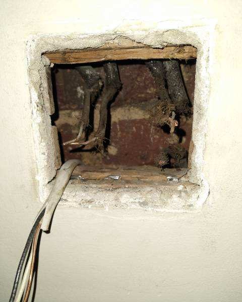 Brittle old cloth-insulated wiring exposed in a wall opening of a 1930s-era Newnan home before rewiring