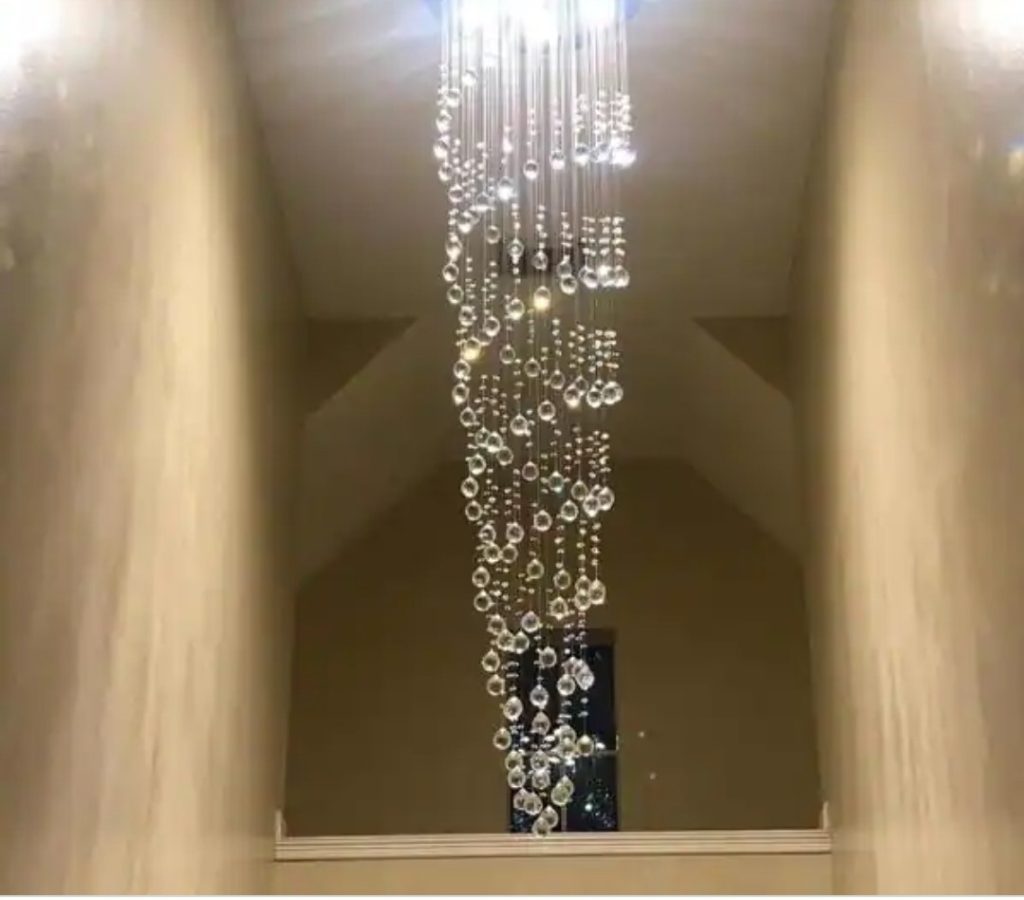Crystal chandelier installed in a two-story foyer by Shocking Electric Solutions