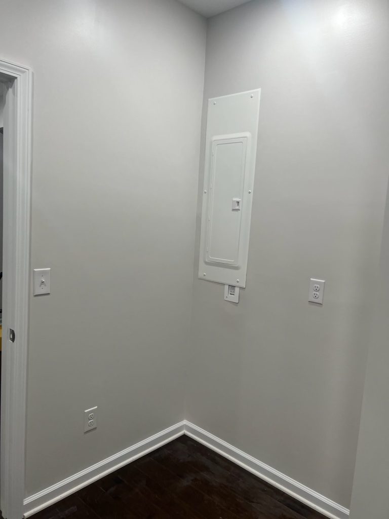 Finished electrical panel installed flush in a hallway wall by Shocking Electric Solutions