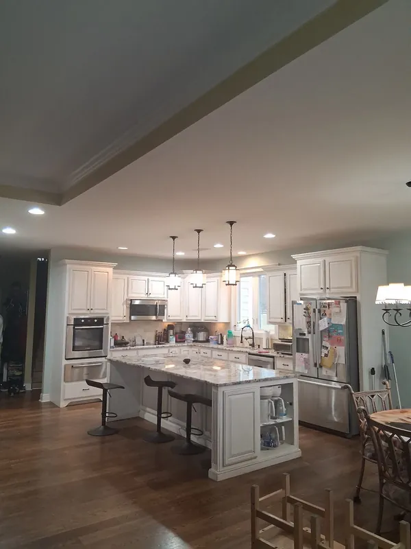 Recessed ceiling lights and pendant lights over a kitchen island in a Newnan, GA home, installed by Shocking Electric Solutions