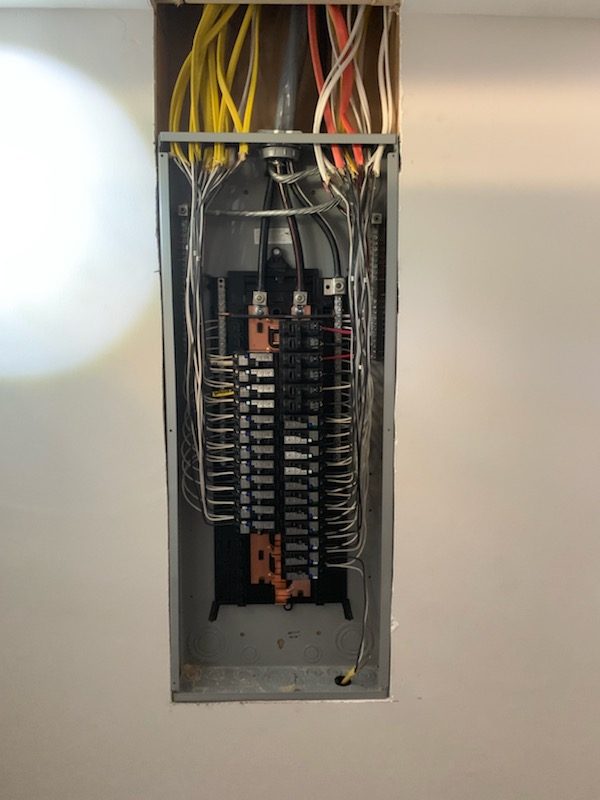 Newly wired residential electrical panel with neat breaker connections, cover off, by Shocking Electric Solutions