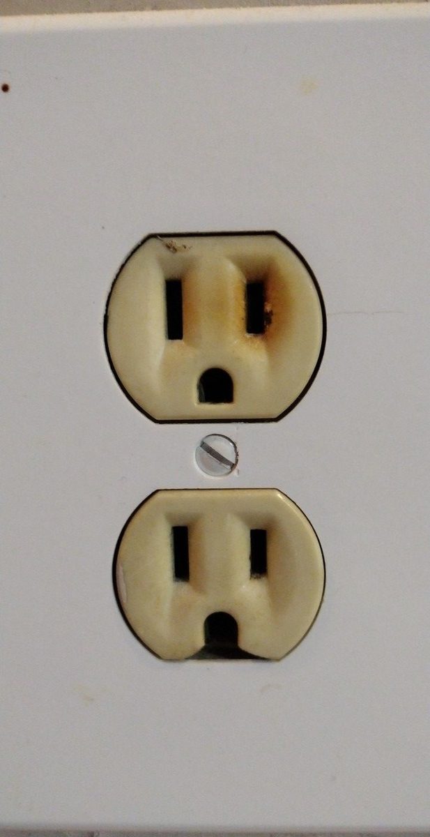 Wall outlet with scorch marks around one slot from space heater overload, found by Shocking Electric Solutions in Newnan, GA